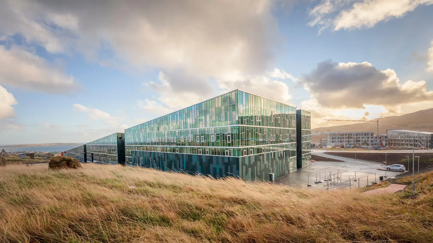 Large glass curtain wall building in the Faroe Islands landscape – aluminum curtain walls featured on Schüco Curtain Wall Systems USA | FWS & AOC Façades