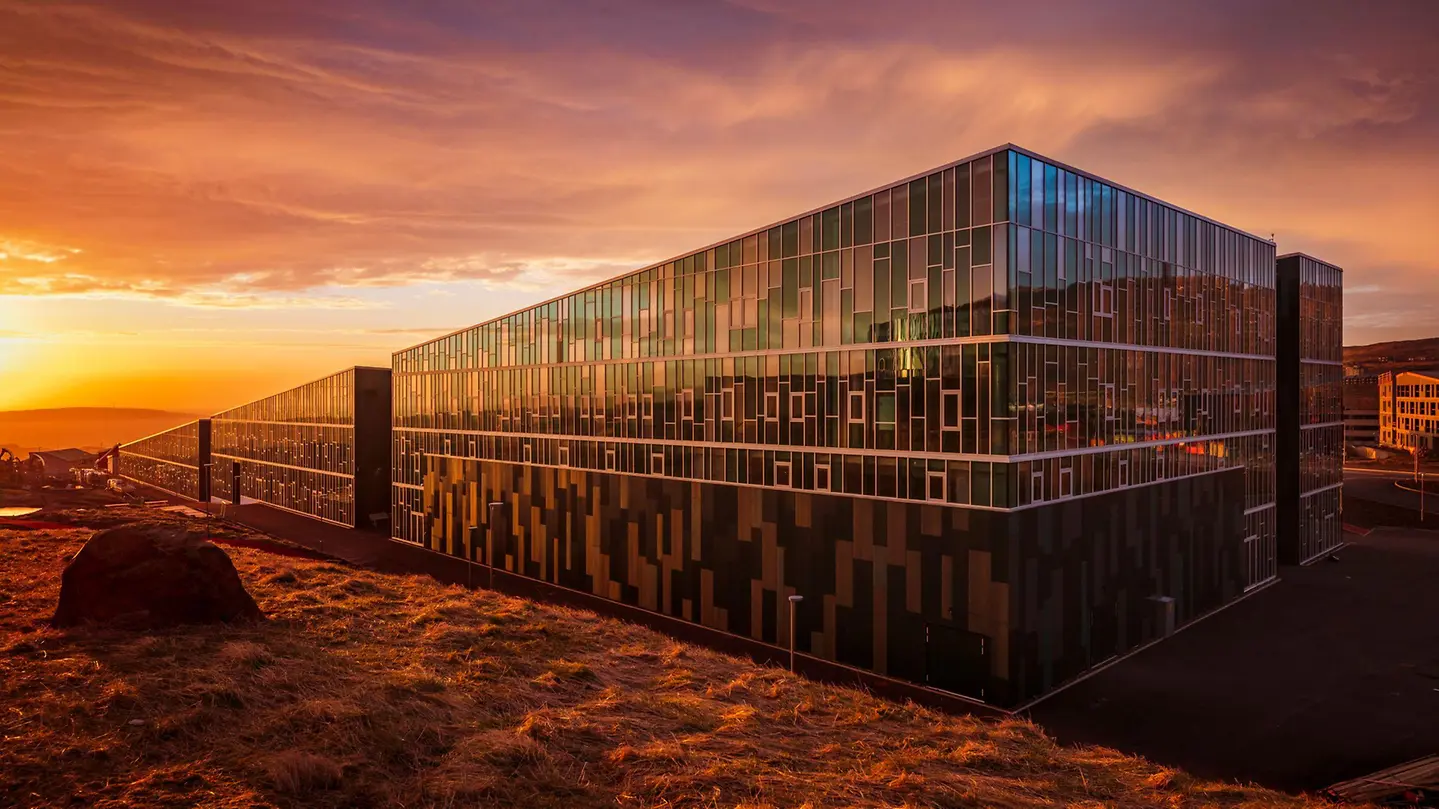Schüco FWS 50 glass façade reflecting a dramatic sunset – aluminum curtain walls featured on Schüco Curtain Wall Systems USA | FWS & AOC Façades