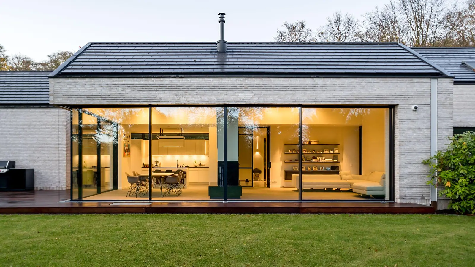 Morn house with frameless all-glass corner glazing made of aluminum in the evening