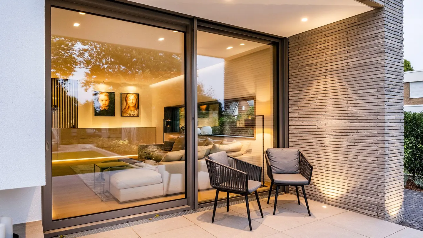 Close view of Schüco ASE 80 sliding doors beside a terrace – aluminum sliding doors featured on Schüco Sliding Glass Doors USA | ASE & Panorama