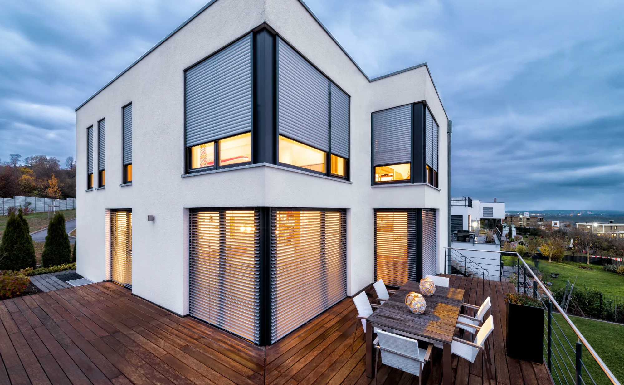 Morn house with external aluminum sunscreen – Raw stores and roller shutters on corner windows at dusk